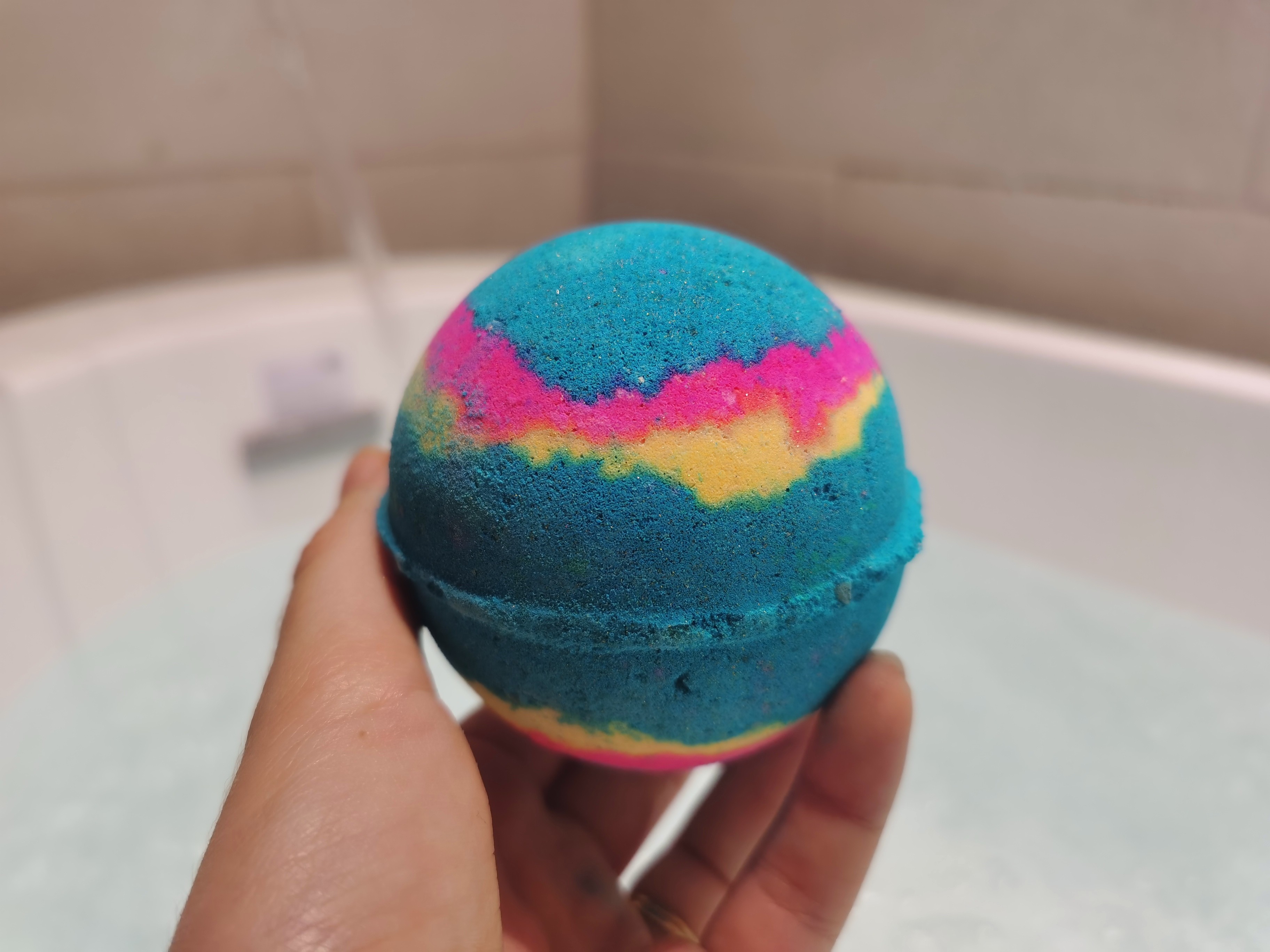 Intergalactic Bath Bomb by Lush in front of a bath filling with water