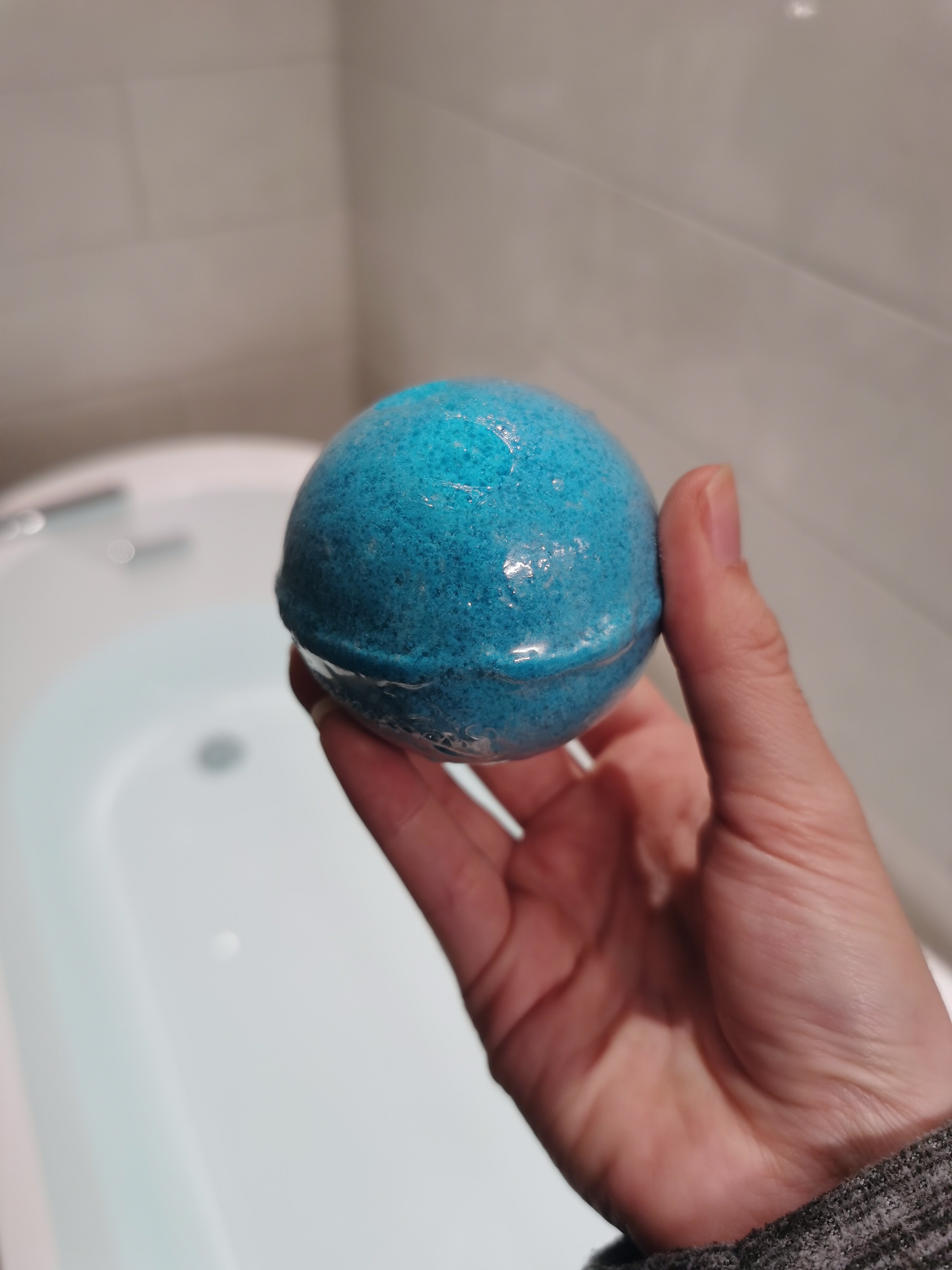 Mermaid Bath Bomb by Me!Bath in front of bath with water