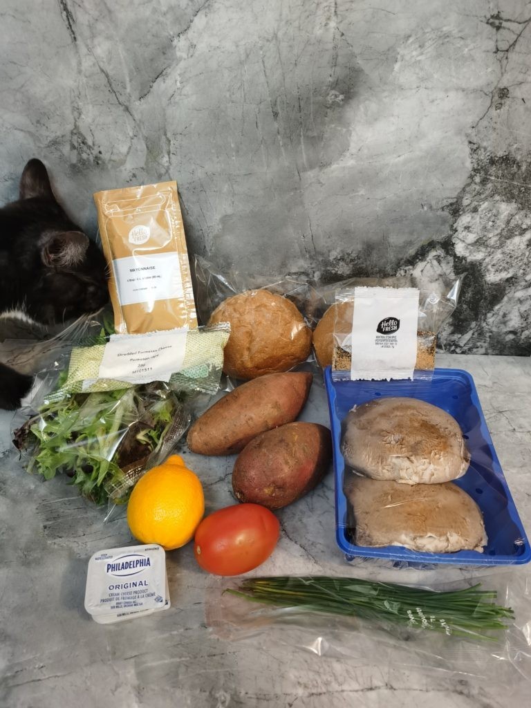 Cat trying to eat ingredients for recipe on marble backdrop