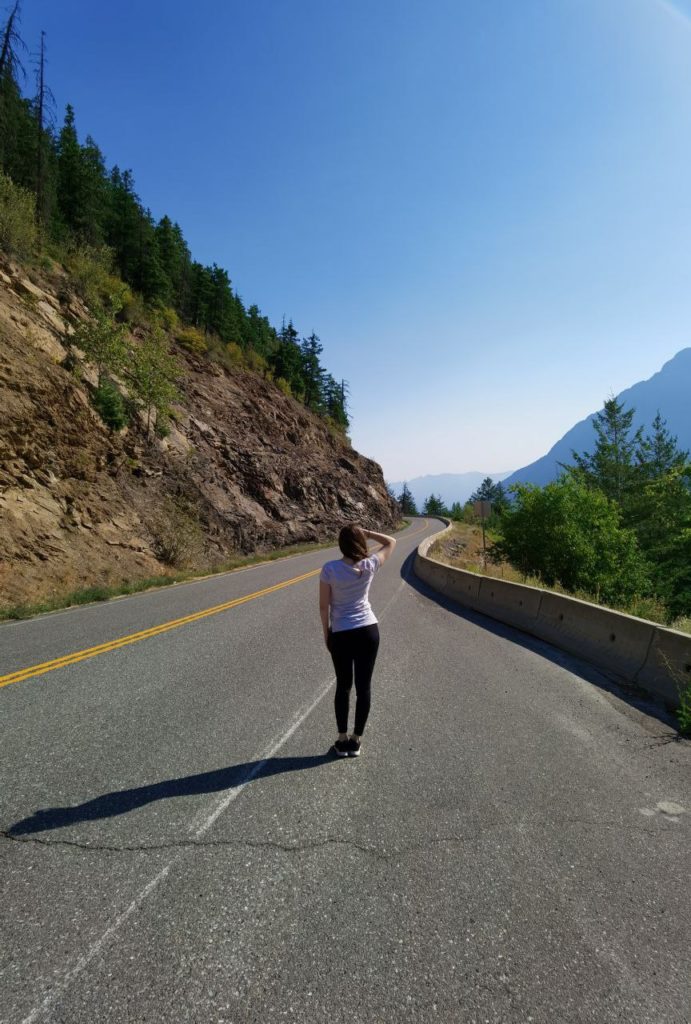 Woman standing in the middle of the road in the canadian rockies