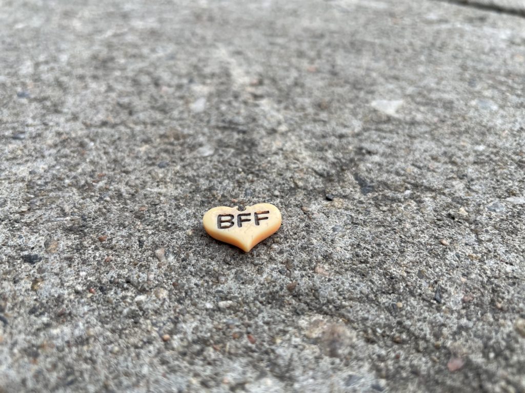 BFF golden charm in the shape of a heart on the sidewalk in Montrel