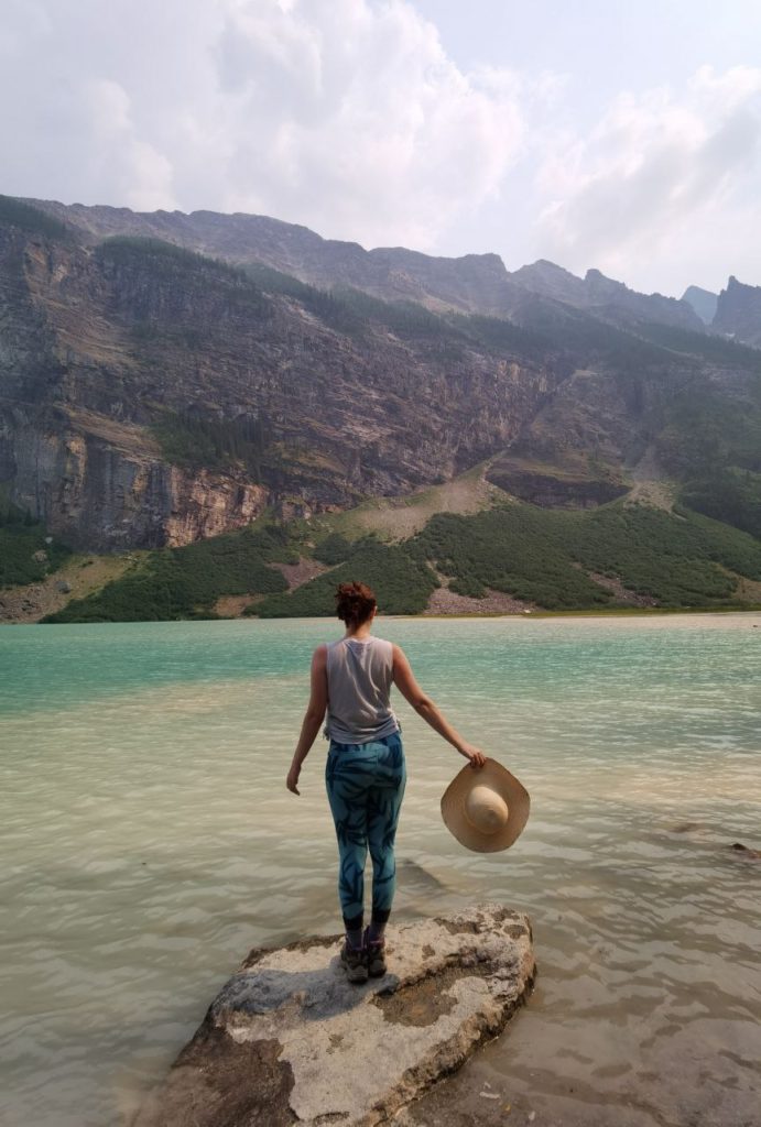 Woman in front of Lake Louise inBanff National Park holding a sunhat