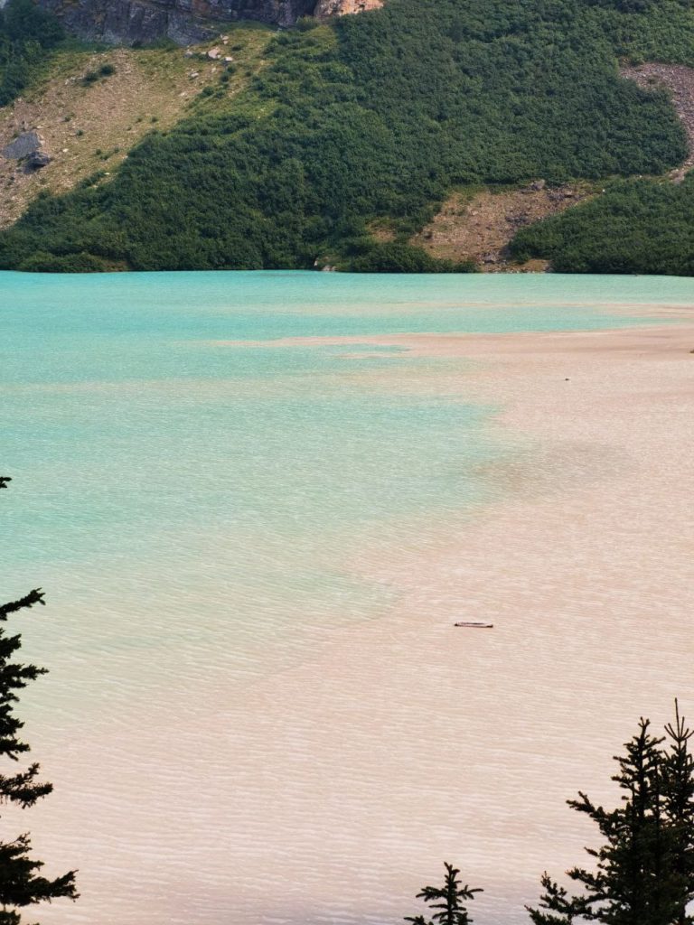 Lake Louise Banff National Park from a distance where the beige sand mixes with the turquoise waters